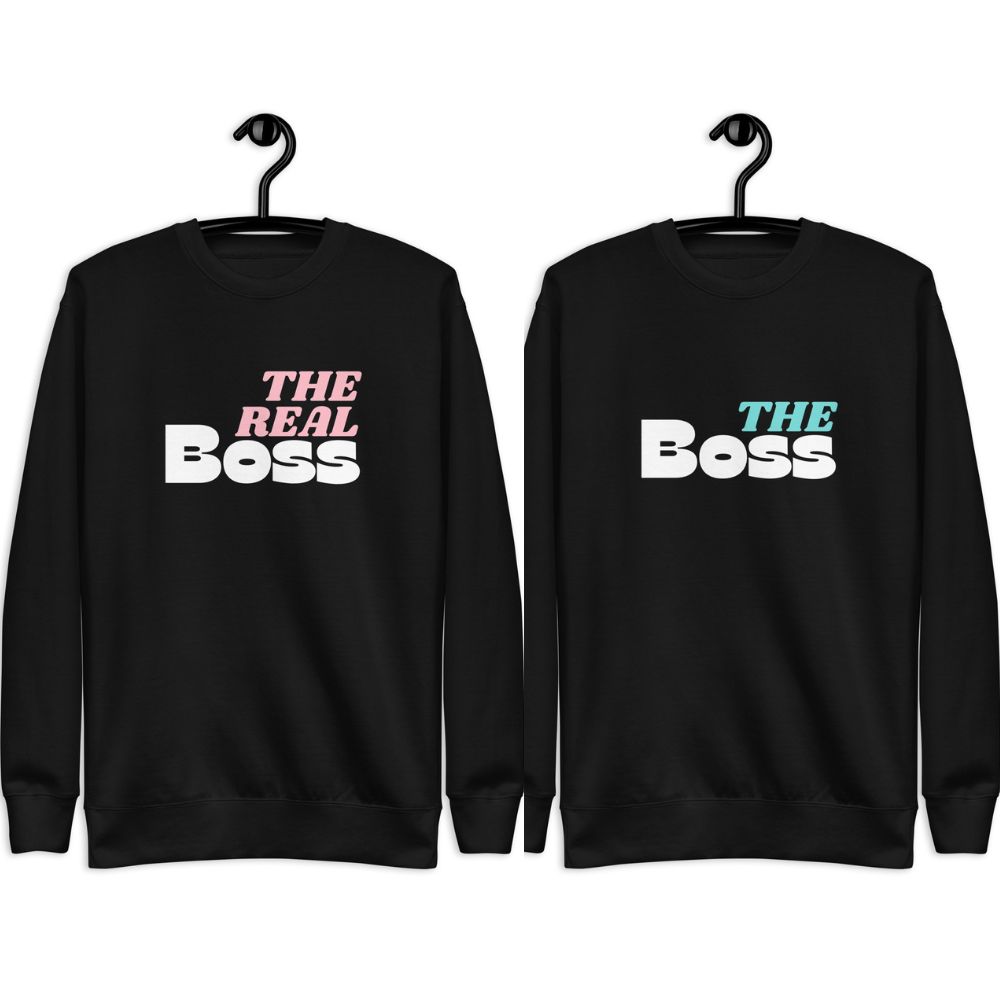 Two matching black sweatshirts with THE REAL BOSS and THE BOSS text in pink and blue