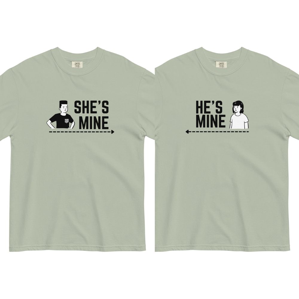 Two matching light green t-shirts with SHE'S MINE and HE'S MINE printed on them, featuring stick figures with arrows